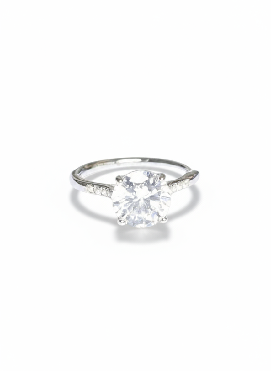 Anello solitario in oro con diamante lucido, firmato Glamorizе Studio, mostrato in primo piano su sfondo neutro.