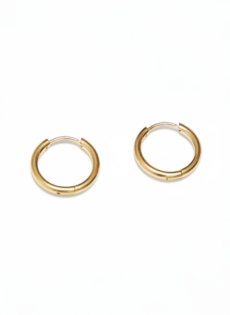 Orecchini Circle Essential di GLAMORIZE STUDIO, orecchini a cerchio minimalisti in metallo dorato, visibili in primo piano.